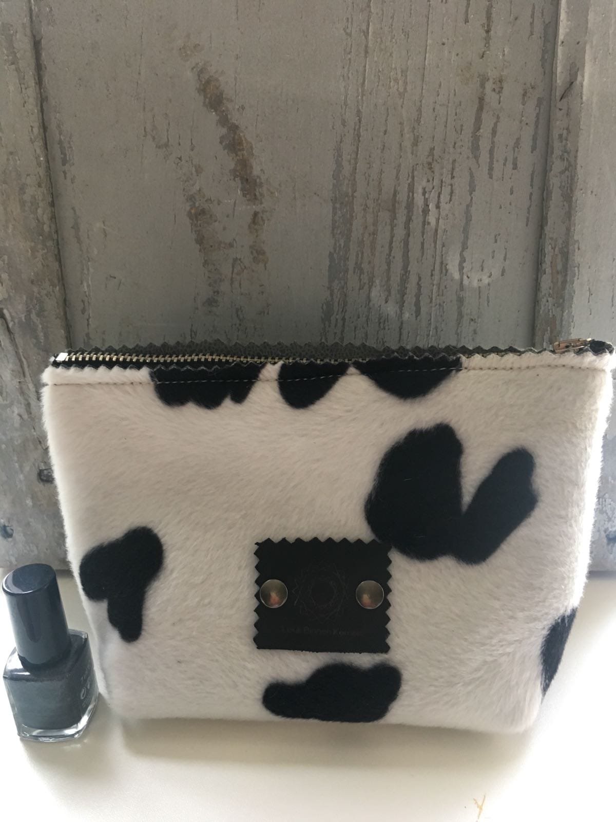 Make-up tasje van bontachtige stof in zwart witte koeienprint