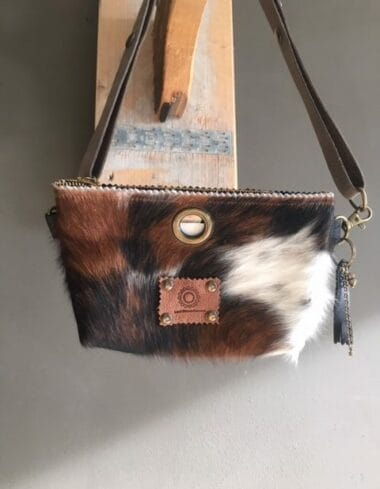 Heuptasje van koeienhuid en zwart leer, met verstelbare leren riem