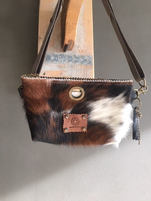 Heuptasje van koeienhuid en zwart leer, met verstelbare leren riem