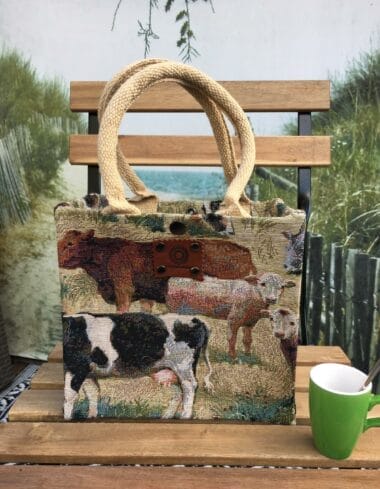 Kleine jute tas bekleed met gobelin waarop koeien afgebeeld staan