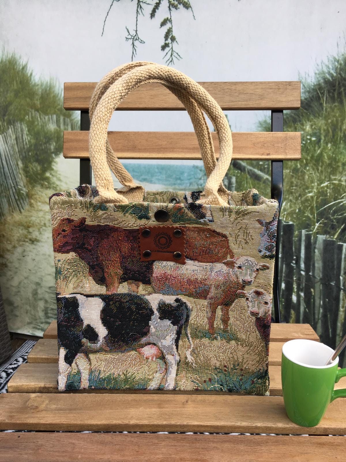 Kleine jute tas bekleed met gobelin waarop koeien afgebeeld staan