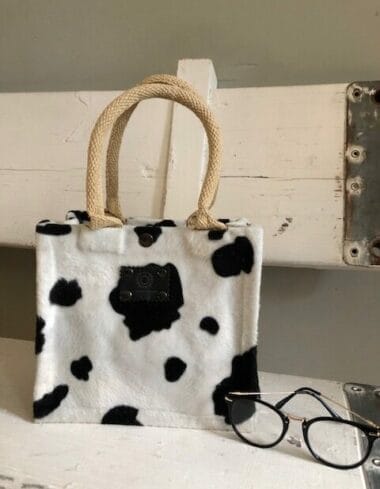 Kleine jute tas bekleed met bontachtige zwart witte koeienprint