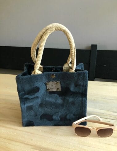 Klein jute tasje bekleed met bontachtig donker petrolgroene stof