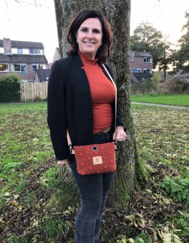 Cross-over tasje van roestbruine coocked wool met roze nopjes