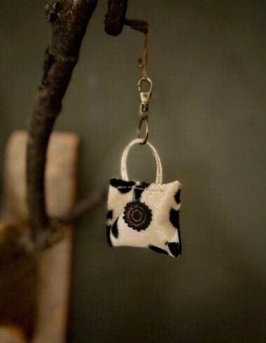 Minitasje sleutelhanger van zachte beige stof met hondenpootjes